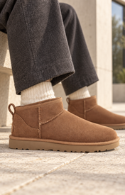 UGG Classic Ultra Mini Chestnut in cognac suede gedragen op natuurstenen bestrating — ROVARO foto 2 4349b7c6bd0af7df
