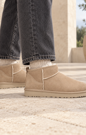 UGG Classic Ultra Mini Sand Beige gedragen op een rustige stenen terrasvloer — ROVARO foto 2 6facdb3f375b86d6
