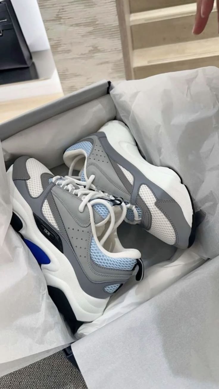 Blue ASICS sneakers on a shoebox